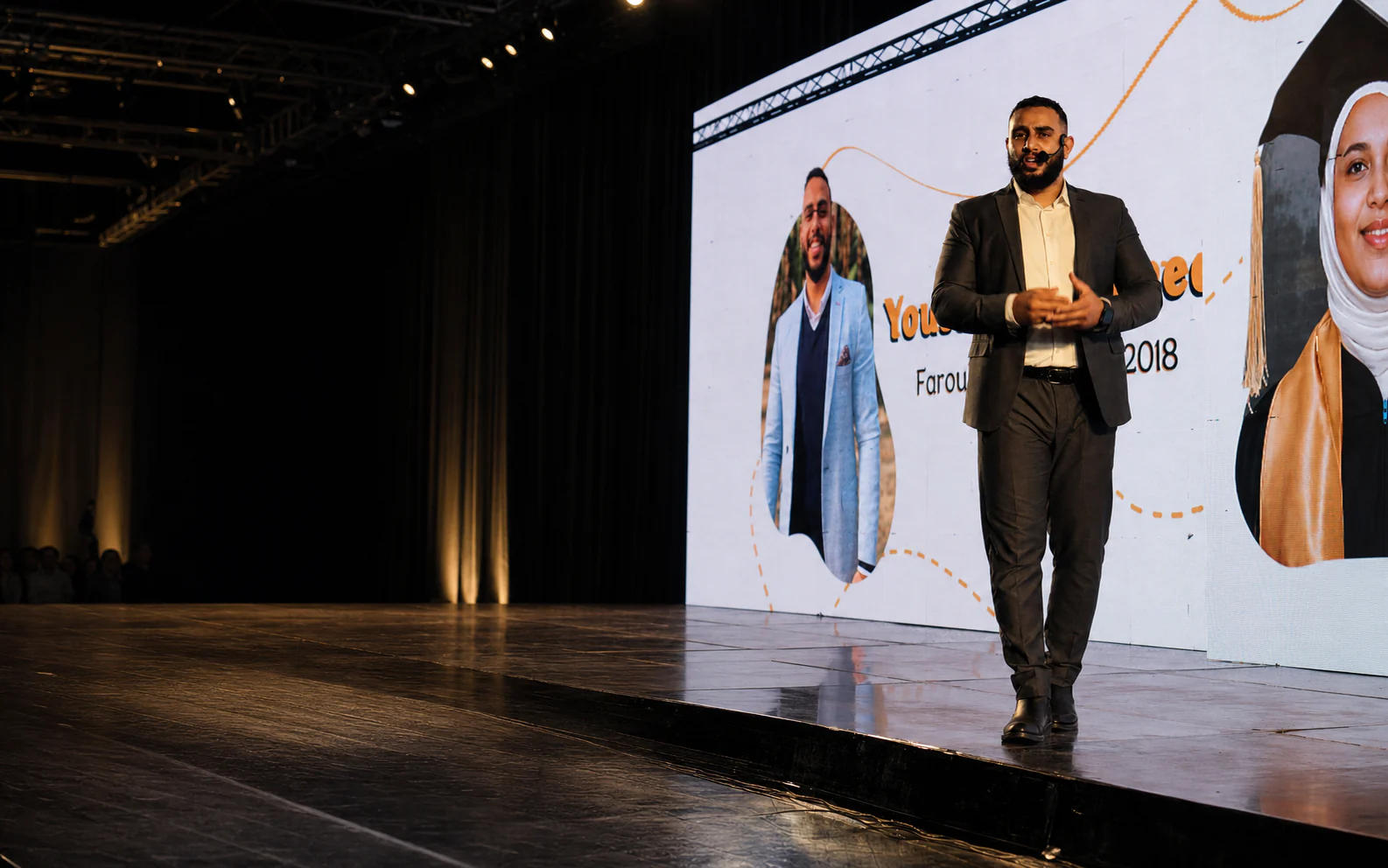 Yousef Mohamed speaking on stage at an education event.